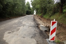 rozkopany teren pod budowe chodnika, z przodu stoi pachołek