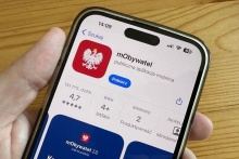 telefon kjomórkowy trzymany w ręce  na nim otwarte mObywatel