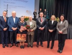 grupa ludzi w eleganckich strojach fotografują się wspólnie na gali 