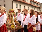 grupa ludzi idąca w korowodzie dożynkowym, ubrana w stroje regionalne