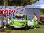 ZIELONY SAMOCHÓD MARKI FIAT 126 P, Z LUDŹMI OBOK DRZWI