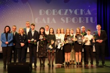 na scenie stoją w dwóch rzędach przedstawiciele samorządu wraz z laureatami Nagrody Burmistrza w dziedzinie sportu