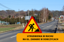 droga przy ul. Zarabie w Dobczycach na środku drogi stoi znak uwaga roboty drogowe poniżej napis utrudnienia w ruchu na ul. zarabie w Dobczycach 