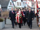 delegacja Rady Miejskiej z wiązanką w tle poczty sztandarowe