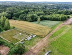 widok z lotu ptaka pola łąki drzewa i budowa drogi na ul. Jałowcowej