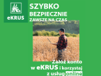 pole zboża na nim uśmiechnięta kobieta w spodniach, koszuli w kratę i czapeczce z laptopem