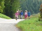 grafika przedstawia dzieci biegnące do lasu