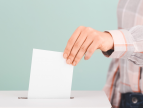 dłoń wrzucająca kartę do głosowania do urny